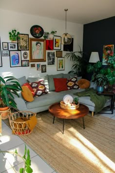 a living room filled with furniture and lots of pictures on the wall above it's coffee table