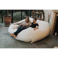 a man and woman sitting on a bean bag chair