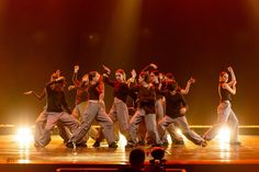 a group of people standing on top of a stage with their arms in the air