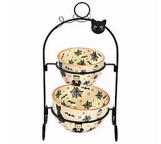 three tiered dish rack with halloween themed dishes on the top and bottom, holding two bowls