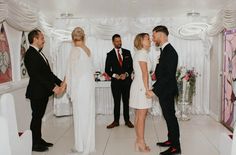 a group of people standing around each other in front of a man and woman on the dance floor