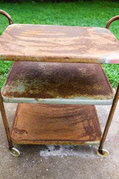 an old rusted metal cart sitting in the grass