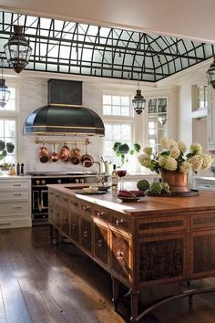 a large kitchen with an island in the middle and lots of pots on top of it