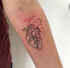 a small heart tattoo on the arm