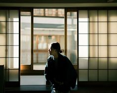 a man sitting on a bench in front of a window