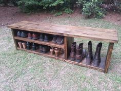 a wooden bench with many pairs of boots on it's shelf in the grass