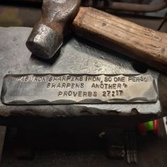 a hammer and an inscription on a piece of metal