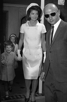 the man and woman are walking down the stairs together with their little children behind them