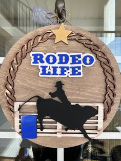 a wooden sign that says rodeo life with a cowboy riding a horse