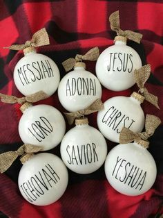 christmas ornaments with names on them sitting on a red and black checkered table cloth