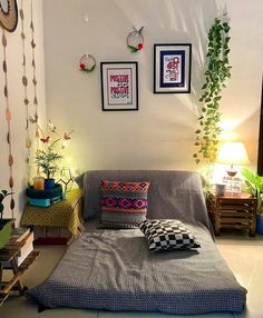 a living room filled with furniture and pictures on the wall next to a bed covered in blankets