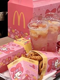 there are many boxes with food in them on the table and one has a hello kitty drink