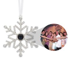 a snowflake ornament with an image of people holding hands and smiling