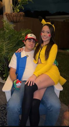 a man and woman in costumes sitting on a bench with their arms around each other