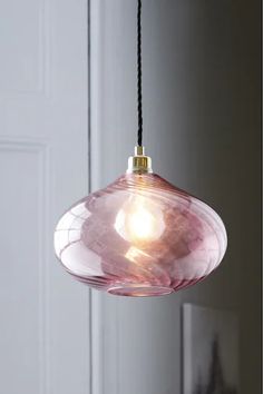 a pink glass light hanging from a ceiling