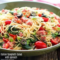 a bowl filled with pasta and vegetables on top of a wooden table