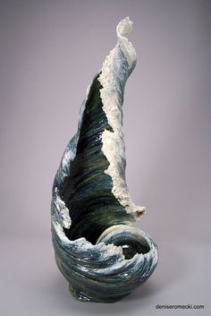 an artistic vase with waves in it on a gray background