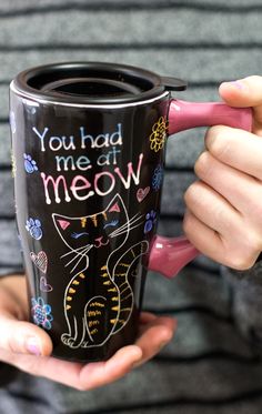 a woman holding a coffee cup with the words you had me at meow written on it