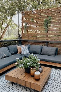 a couch and table on a patio with wooden slatted screens in the background