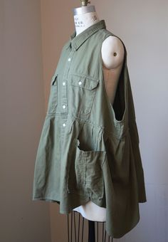 Olive green button down sleeveless smock with large arm holes and large pockets.  Smock has an asymmetrical hem. Made from a deconstructed vintage Levi's button down shirt. 100% Cotton Tag says XXL.  It would fit a range of sizes, depending on how loose or snug you prefer.  Please see measurements below: Measurements (taken w/jacket laid flat): Across chest at underarm: 28.5" Across hem: 48" Shoulder to hem: 30" I like to re-purpose clothing from the thrift store, as opposed to always buying new fabric. It is a challenge to work out the designs and feels like a small way to fight "Fast Fashion". Deconstructed Shirt, Button Down, Green Button, Asymmetrical Hem, Vintage Levis, Dress Clothes For Women, Fast Fashion, Asymmetric Hem, Thrift Store