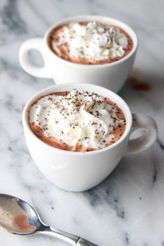 two cups of hot chocolate topped with whipped cream