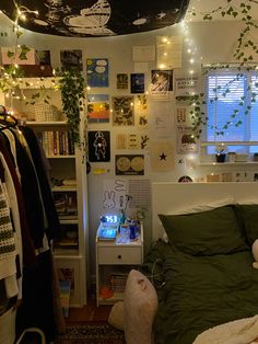 a bed room with a neatly made bed and lots of plants hanging on the wall