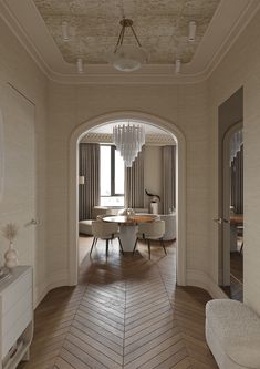 an elegant dining room with wooden floors and chandelier hanging from the ceiling, along with white chairs