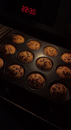 muffins are being cooked in an oven with the timer turned on and red