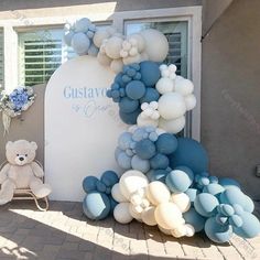 a teddy bear sitting next to a bunch of balloons