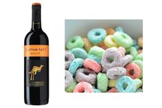 a bottle of wine next to a pile of doughnuts and a bowl of cereal