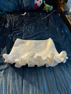 a crocheted diaper is laying on top of a blue bed sheet in a child's bedroom