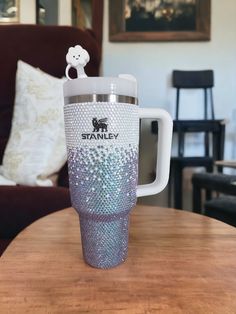 a coffee cup with a teddy bear on it sitting on top of a wooden table