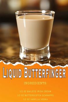 liquid butterfingerer ingredients in a glass on a countertop with orange and white background