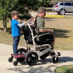 an older man pushing a child in a wheel chair