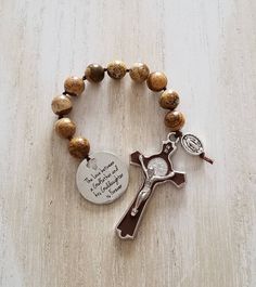 "\"The love between a Godfather and his Goddaughter is forever\" This beautiful, hand made one decade catholic rosary makes a perfect gift for a godfather. Either as a proposal or thank you gift, this is sentimental and will always be cherished.  I made this rosary using ■10 mm smooth round picture jasper beads. These beads are genuine gemstone and are hand knotted into the rosary using nylon thread. This rosary is very durable. ■Silver tone 2 inch cross with brown enamel inlay. Beautifully detailed and high quality  ■Stainless steel charm with unique cross cutout. Laser engraved and hypoallergenic. This rosary will arrive in a pouch ready to be gifted. To view similar items, please visit the link below: https://www.etsy.com/ca/shop/CallystoDesigns?ref=seller-platform-mcnav&section_id=2351 Godfather Proposal, Best Gif, Catholic Rosary, The Rosary, Rosary Catholic, Rosary Beads, Proposal Gifts, Catholic Gifts, Baptism Gifts