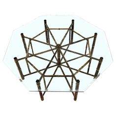 a glass table topped with bamboo sticks and an upside down glass top that is shaped like a star