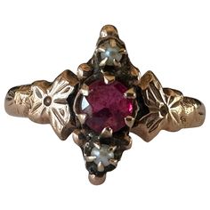 Crafted in the late nineteenth century, this antique Victorian ring is designed around an approximately 0.25-carat ruby and accompanied north and south by two seed pearls and ornately engraved flowers. Set in 10K rose gold. Historic Jewelry, Victorian Wedding Ring, Antique Ruby Ring, Antique Jewelry Victorian, Antique Rings Victorian, Seed Pearl Ring, Victorian Ring, Engraved Flower, North And South