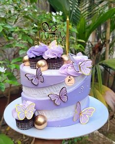 a three tiered cake with purple butterflies on it