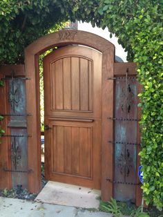 an open wooden door surrounded by greenery