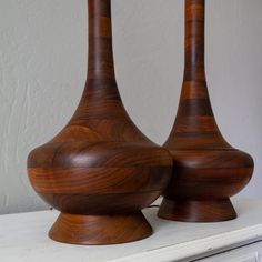 two wooden vases sitting on top of a white table