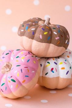 three donuts with sprinkles are stacked on top of each other in front of a polka dot background