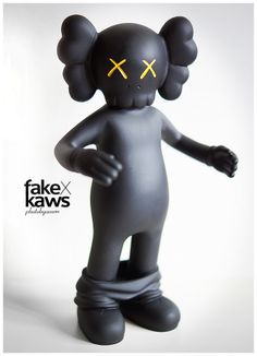 a black toy with yellow crosses on its eyes and ears, standing in front of a white background