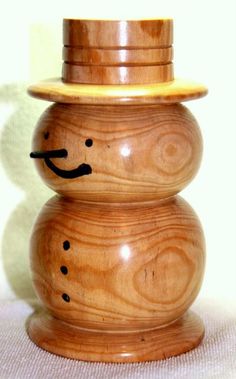 a wooden snowman sitting on top of a table