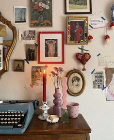 an old typewriter sitting on top of a desk next to pictures and other items