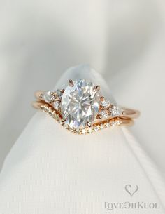 a close up view of a diamond ring on top of a white cloth with gold accents