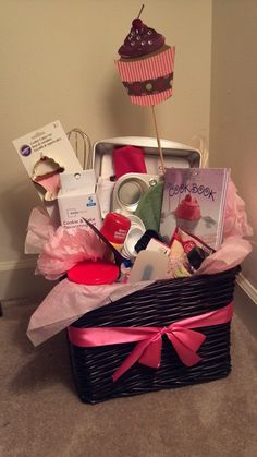 a basket filled with lots of different items next to a cupcake on top of a table