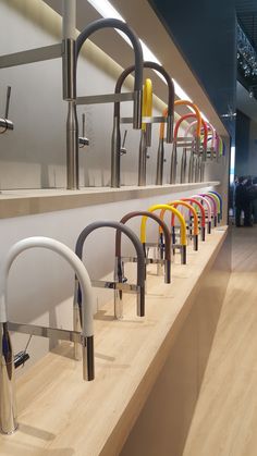 a row of colorful chairs sitting on top of a wooden counter next to a wall