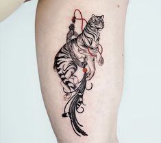 a woman's leg with a tattoo on it and a cat sitting on the thigh