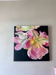 a painting of pink flowers on a black and white background is hanging on the wall