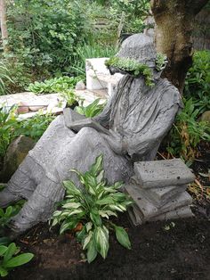 a statue sitting in the middle of a garden